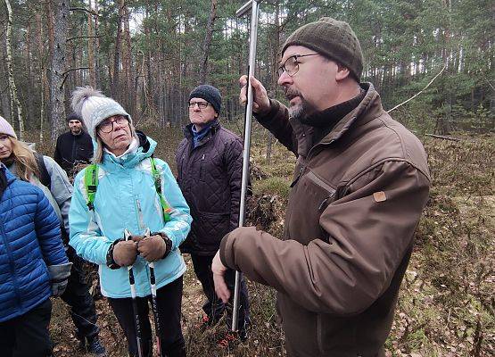 Na zdjęciu prowadzący zajęcia trzymający w ręku rurkę do pobierania profilu glebowego.