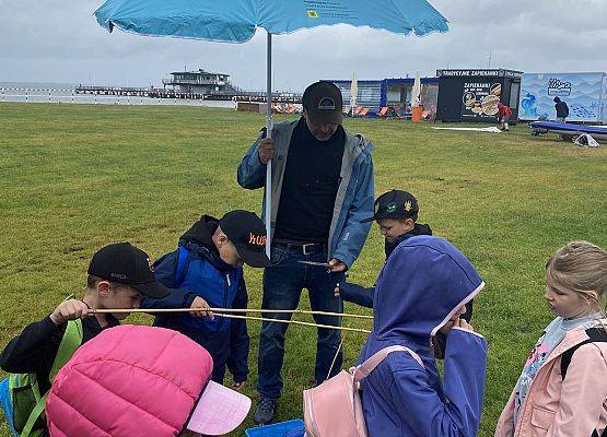 Dzieci łowiące drewniane ryby za pomocą wędek bambusowych