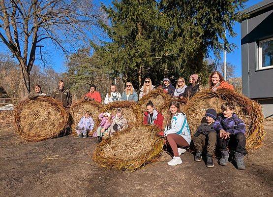 Grupa ludzi prezentuje 6 gotowych podstaw pod bocianie gniazda.