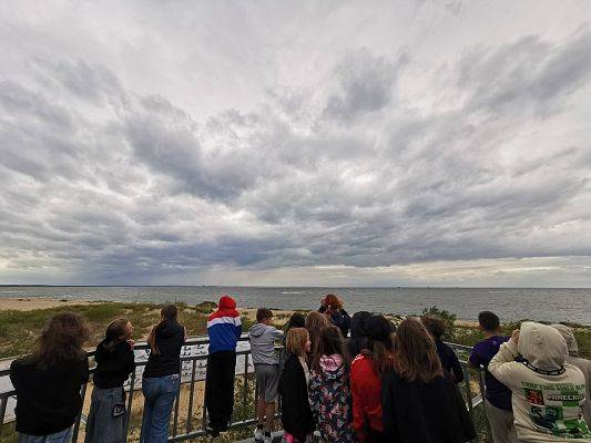 W ujściu Wisły, fot. JKR Grupa osób na wieży obserwacyjnej nad morzem.
