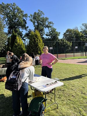 Co się kryje w tych tajemniczych woreczkach? fot. AB przy stole postawionym przy boisku szkolnym dwie osoby wkładają ręce do woreczków.