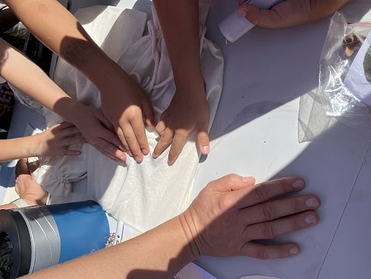 Rozpoznaj co kryje się w woreczku. fot. AB zbliżenie na ręce które dotykają tego co ukryte jest w bawełnianych woreczkach.